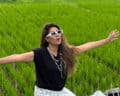 Beautiful woman enjoying Bali rice fields during group tour.