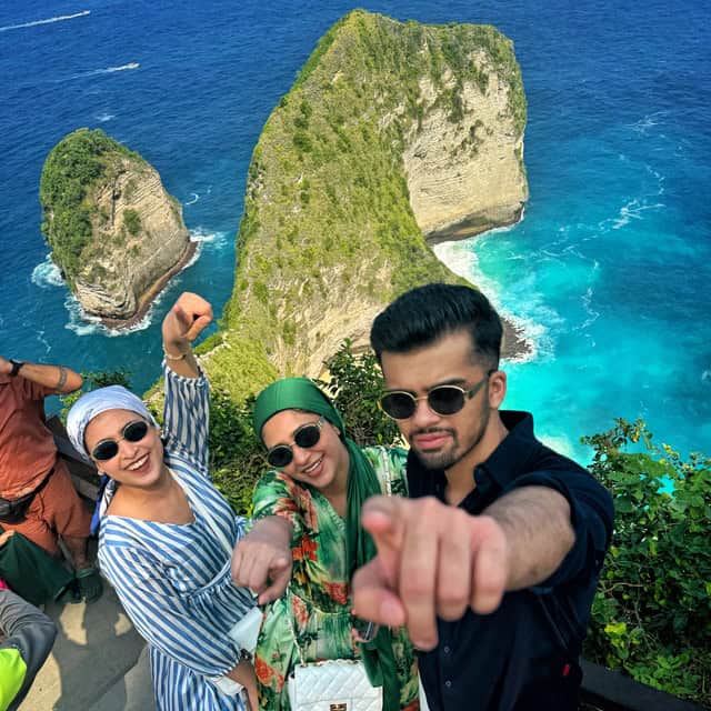 Pakistani tourists posing in front of a cliff on Kelingking beach, Nusa Penida island