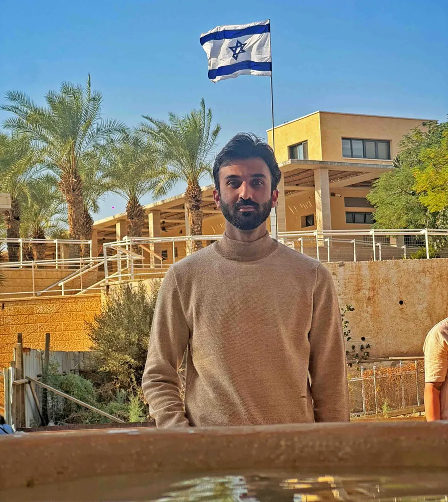 The Israeli flag visible across the Jordan River on the West Bank, seen from the Jordanian baptism site waterfront