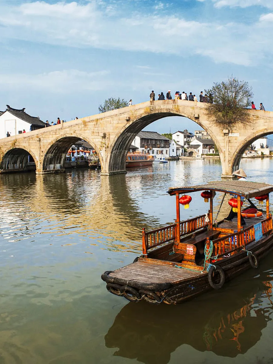 Ancient stone arch bridge and wooden boat at Zhujiajiao water town, Shanghai